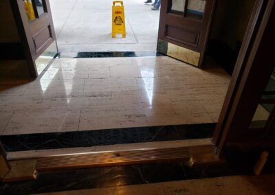 Marble Lite Inc. project entrance with caution sign for floor polishing services at a New York business.
